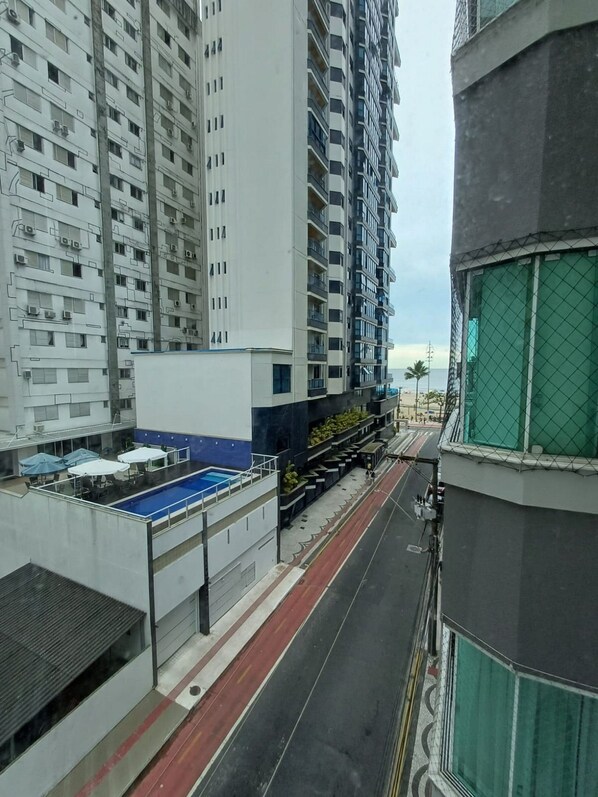 A high-rise building with multiple balconies and a swimming pool area. - Ap Vista Mar - Ed Belo Mar - BC (Balneário Camboriú)