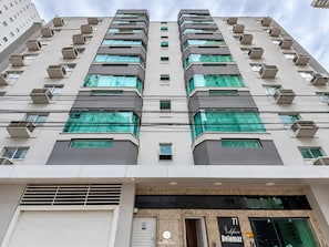 A multi-story building with a modern architectural design, featuring a series of balconies and air conditioning units. - Ap Vista Mar - Ed Belo Mar - BC (Balneário Camboriú)
