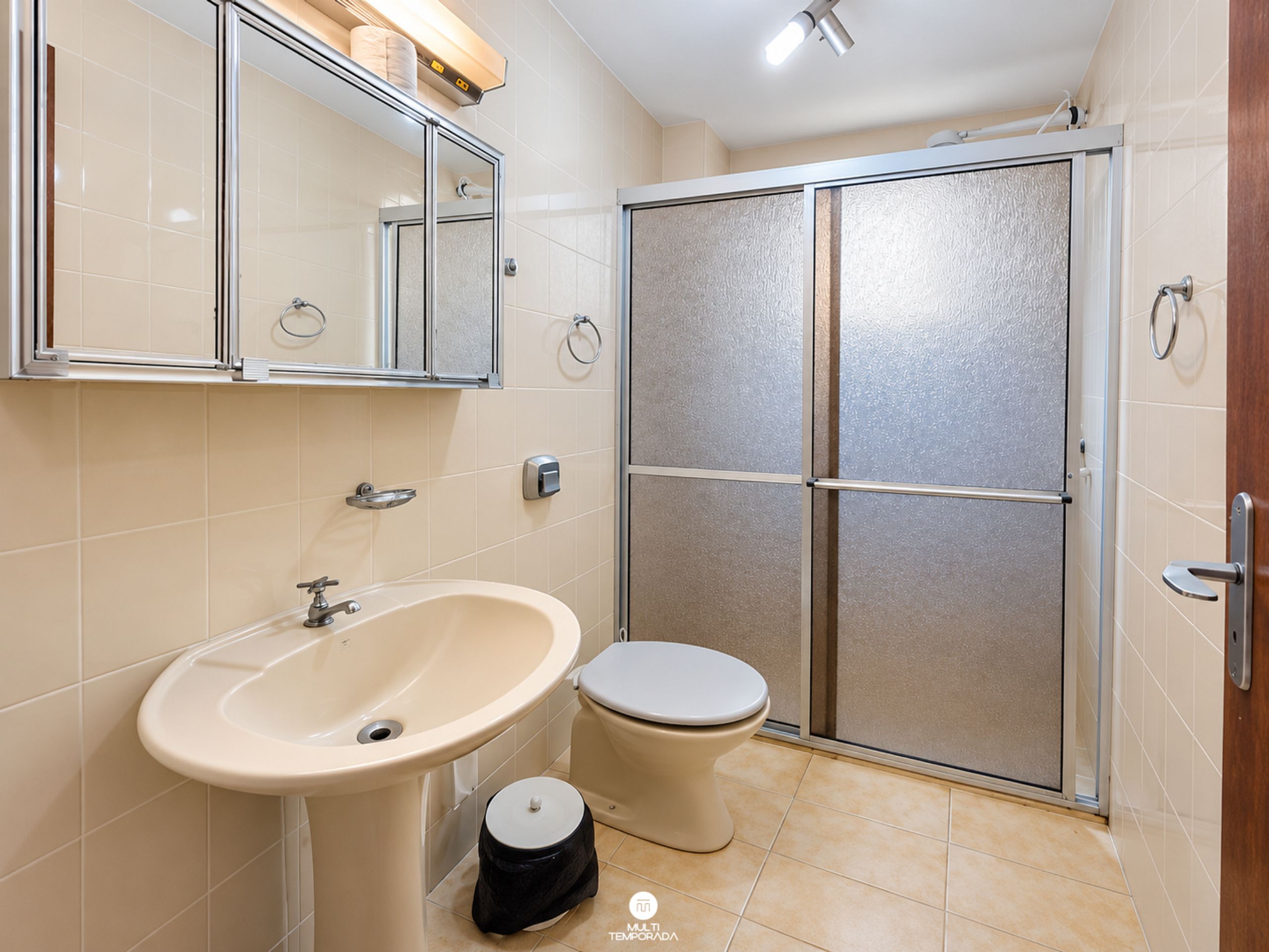 Une salle de bain équipée d’un lavabo, de toilettes et d’un espace douche.