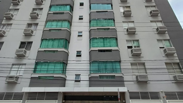 Un edificio moderno e imponente con numerosi balconi e condizionatori.
