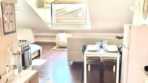 Une cuisine moderne avec un coin repas, un plancher en bois et un plafond de style industriel.