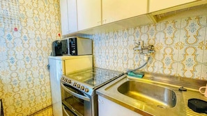 A compact kitchen with a microwave, toaster, and sink.