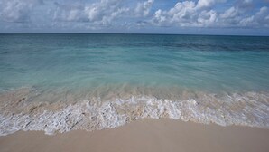 Una playa con agua turquesa cristalina y una orilla arenosa.