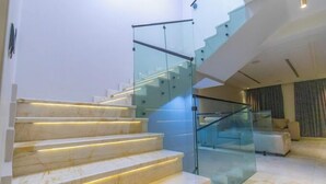Un escalier moderne avec des rampes en verre et des marches éclairées.
