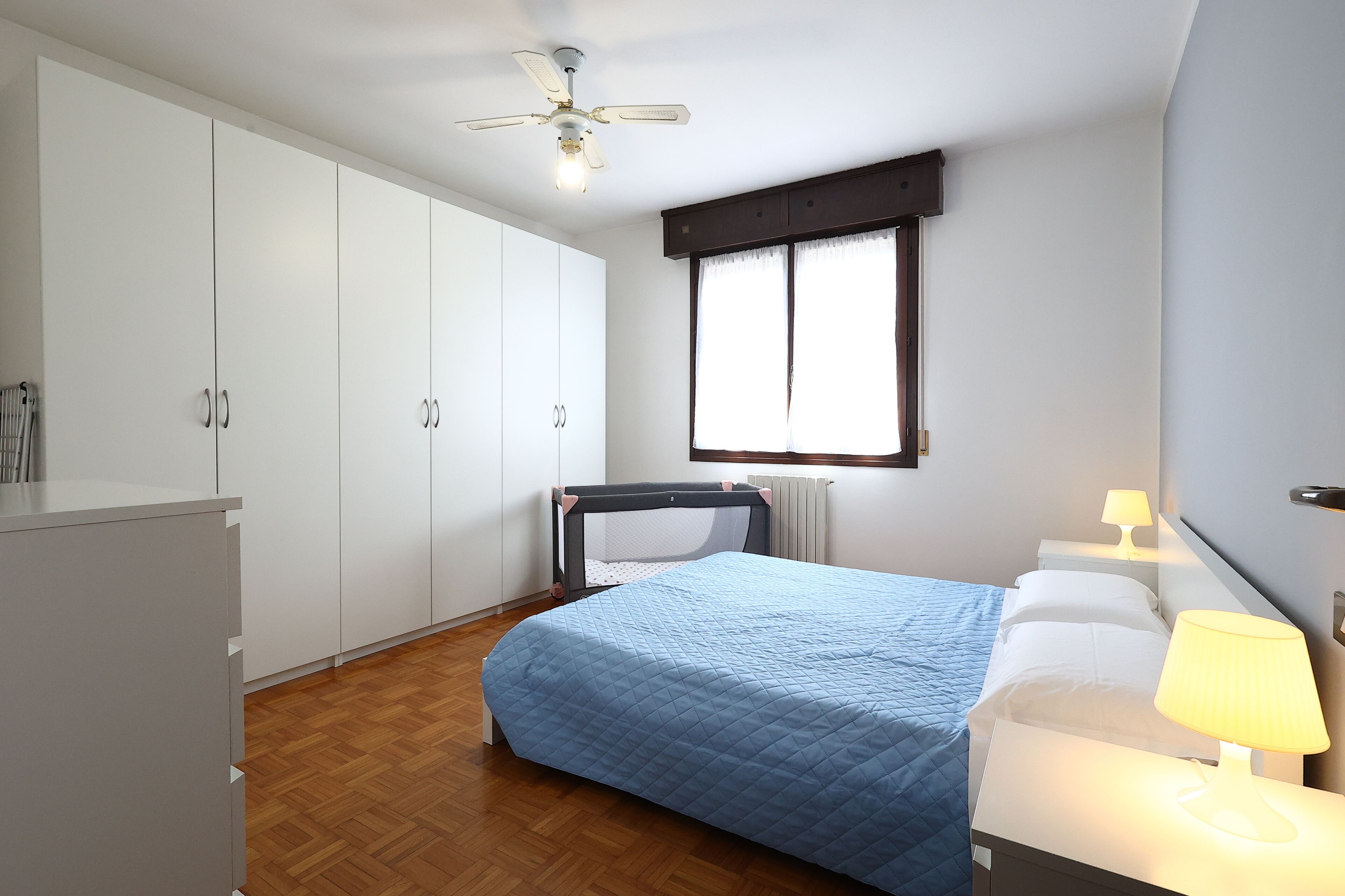 Ein Schlafzimmer mit einem Bett, einem Nachttisch, einem Schreibtisch und einem Kleiderschrank.