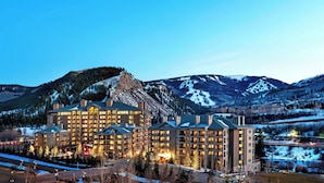 A multi-story hotel with a central courtyard, surrounded by snow-covered mountains and a ski resort. - Beaver Creek Solace by Avantstay Studio w/ Resort Pool + Hot Tub Premier Avon Location (Avon)