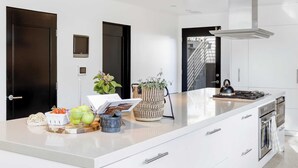 A modern kitchen with a large island, stainless steel appliances, and a sleek design.