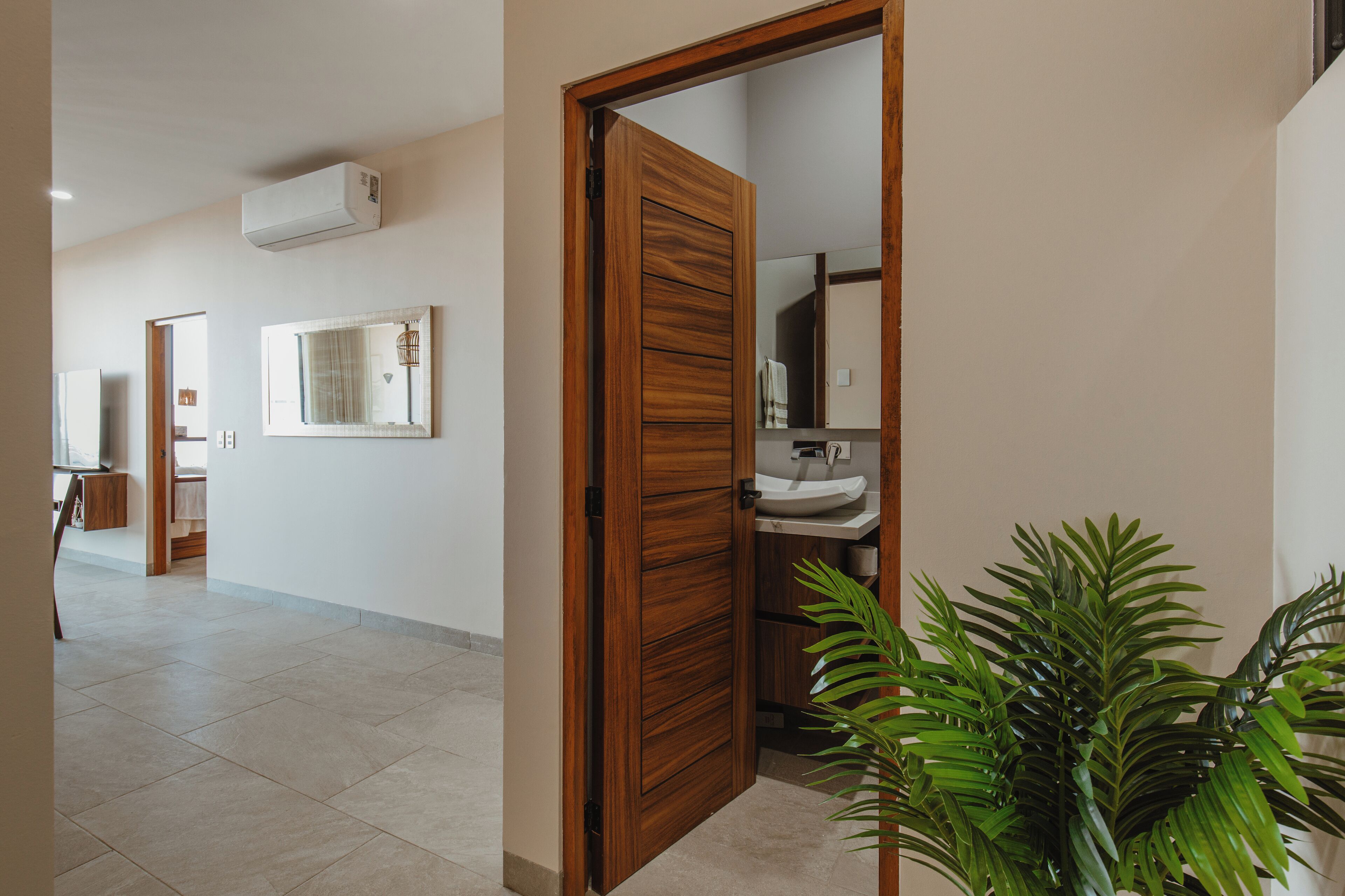 Un pasillo con una puerta de madera que da a un baño.