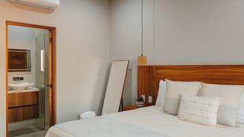 Une chambre à coucher moderne avec un grand lit, une table de chevet et un miroir.