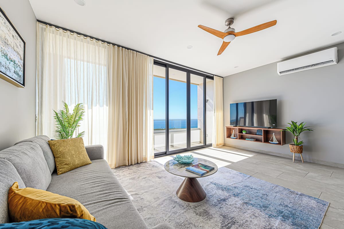 A modern living room with a sofa, coffee table, and a TV.