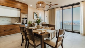 Zona pranzo moderna con tavolo in legno, sedie e ventilatore a soffitto.