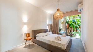 Une chambre à coucher avec un lit, une lampe de chevet et une vue sur la verdure.