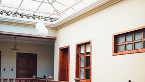 Een ruime binnenruimte met een hoge plafond, houten leuning en grote ramen voor natuurlijk licht.