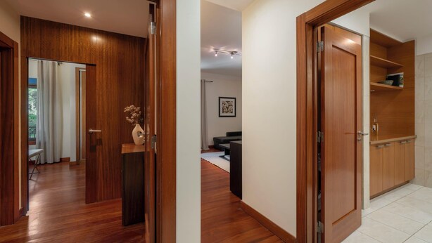 Un corridoio con pavimento in legno e porte che conducono a diverse stanze.