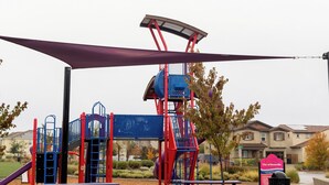 Un’area giochi con una struttura per arrampicata, scivoli e tavoli da picnic.