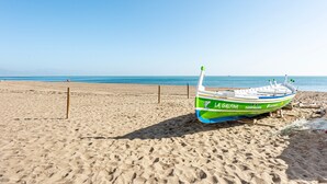 Un bote llamado 'LA GALFINA' en una playa arenosa con el océano al fondo.