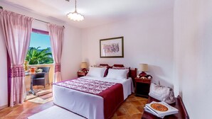 Habitación de hotel con cama, mesitas de noche, escritorio y vistas al exterior.