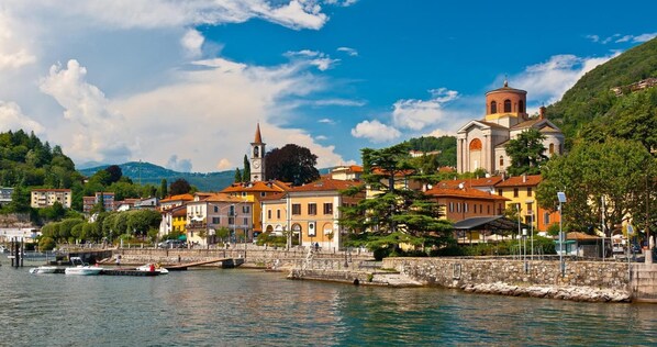 A waterfront town with historic buildings, a church, and a bridge. - Apartment in Luino With Lake Maggiore Views (Luino)
