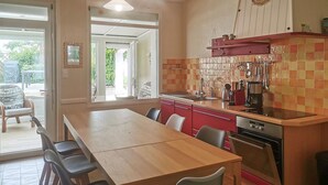 Una cucina moderna con un tavolo e sedie in legno, un pensile rosso e uno schienale piastrellato.