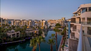 A resort with multiple buildings, a marina, and a swimming pool surrounded by palm trees. - The Canal Three Bedroom Pool Duplex Penthouse - 007 (Cape Town)