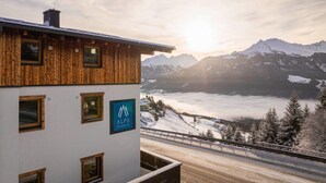 A building with a wooden facade and a sign for ALPS RESORTS. - Studio Near the Slopes With Wellness Area (Mittersill)