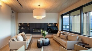 Una sala de estar moderna con chimenea, sofás y un ventanal con vistas.