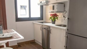 A compact kitchen with a dishwasher, a refrigerator, and a microwave. - Elegante y Luminoso Piso Reci n Reformado (La Victoria de Acentejo)