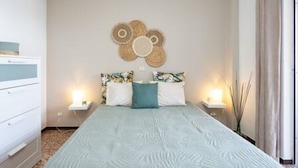 A bedroom with a bed, two bedside tables, a wall decoration, and a window with curtains. - Coral Sunsent View With 1 Bedrooms and 1 5 Bathrooms (Tacoronte)