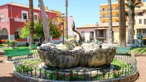 A fountain with a unique design, surrounded by a circular fence and a variety of plants. - Apartamento Atardecer Martianez (Puerto de la Cruz)