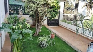 A small, well-maintained garden area with a lawn, a tree, and a metal sculpture. - Espectacular Villa con Piscina y Vistas al Valle (La Orotava)