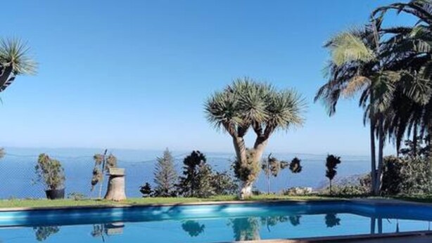 A swimming pool with a clear view of the ocean and palm trees. - Espectacular Villa con Piscina y Vistas al Valle (La Orotava)