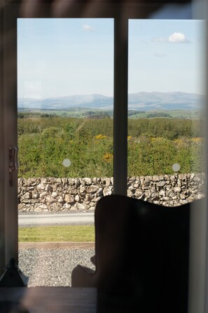 A view through a doorway with a stone wall and a road visible in the foreground.