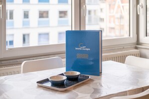 A table with a blue menu stand, two bowls, and a tray in a room with a window view.