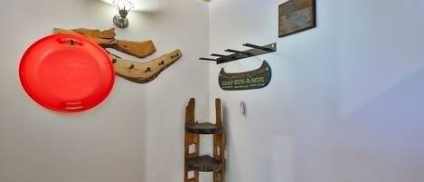 A corner of a room with a wooden shelf, a red object, and a welcome sign.
