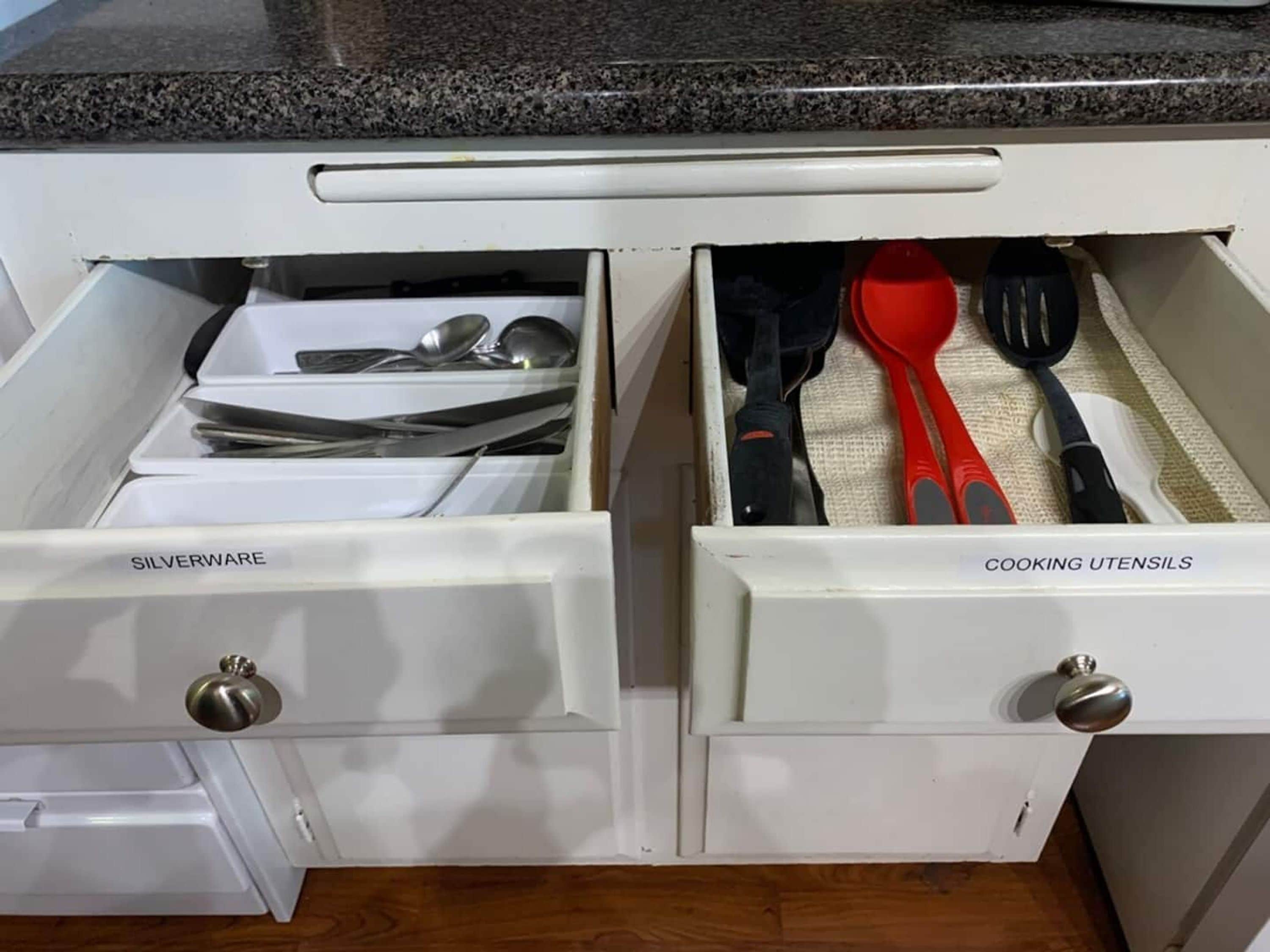 A kitchen drawer with compartments labeled 'SILVERWARE' and 'COOKING UTENSILS,' containing various kitchen items.