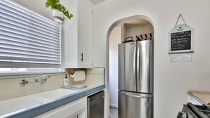A modern kitchen with a stainless steel refrigerator, a dishwasher, and a stove. - Normal Heights Hideaway (San Diego)