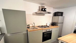 A compact kitchen with a refrigerator, stove, microwave, and sink. - Charming 2-bedroom house in lovely Catania with WiFi, AC (Catania)