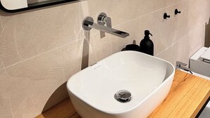 A modern bathroom with a white sink, a mirror, and a wall-mounted towel rack. - Charming 2-bedroom house in lovely Catania with WiFi, AC (Catania)