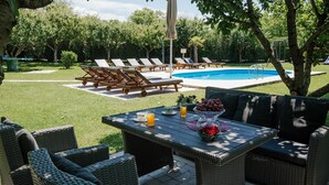 An outdoor patio area with wicker furniture, a pool, and lounge chairs. - Villa in Croatia Near Blue & Red Lakes (Imotski)