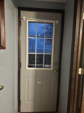 A door with a window, a lock, and a small sticker.