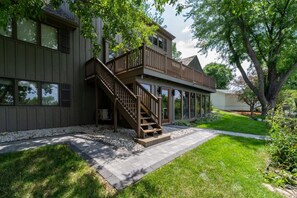 A two-story house with a wooden deck and a staircase leading to the second floor. - Astoria on Yellowstone (Sioux Falls)