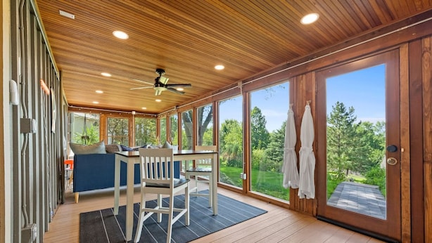 A spacious room with a wooden ceiling, large windows, and a view of the outdoors. - Astoria on Yellowstone (Sioux Falls)
