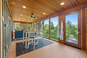 A spacious room with a wooden ceiling, large windows, and a view of the outdoors. - Astoria on Yellowstone (Sioux Falls)