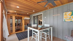 A dining area with a wooden table and chairs, a ceiling fan, and a grey wall with a framed artwork. - Astoria on Yellowstone (Sioux Falls)