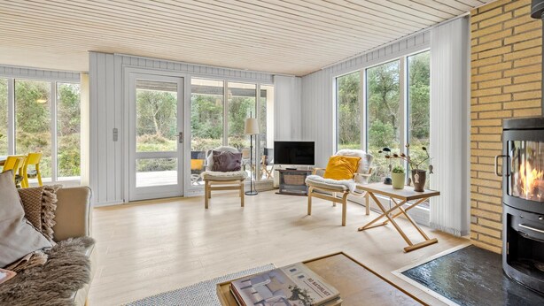 A spacious living room with a fireplace, large windows, and a cozy seating area. - 3 bedroom awesome home in Ringkøbing (Ringkøbing)