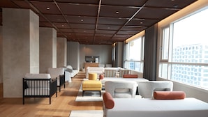 A modern hotel room with a large bed, multiple seating areas, a kitchenette, and a view of the city. - New Blanc Central Myeongdong (Seoul)