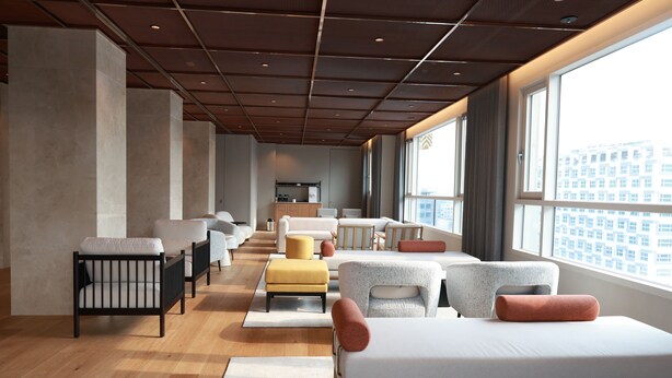 A modern hotel room with a large bed, multiple seating areas, a kitchenette, and a view of the city. - New Blanc Central Myeongdong (Seoul)