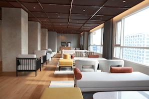 A modern hotel room with a large bed, multiple seating areas, a kitchenette, and a view of the city. - New Blanc Central Myeongdong (Seoul)