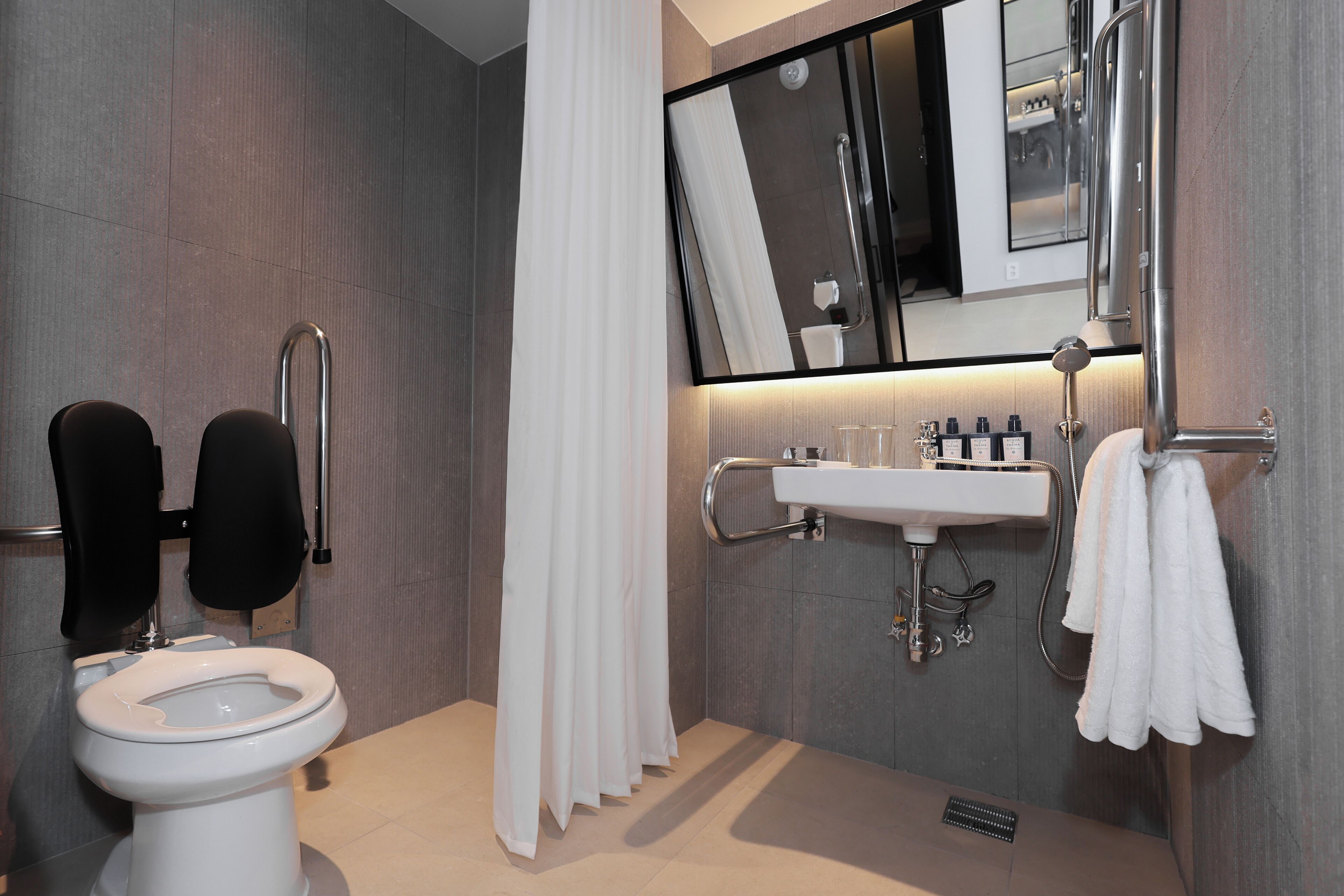 Une salle de bain moderne équipée de toilettes, d’un bidet et d’un lavabo.