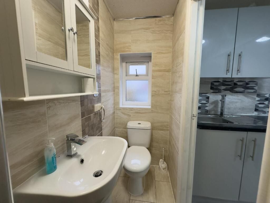 Ein kleines Badezimmer mit Waschbecken, Toilette und Schrank.